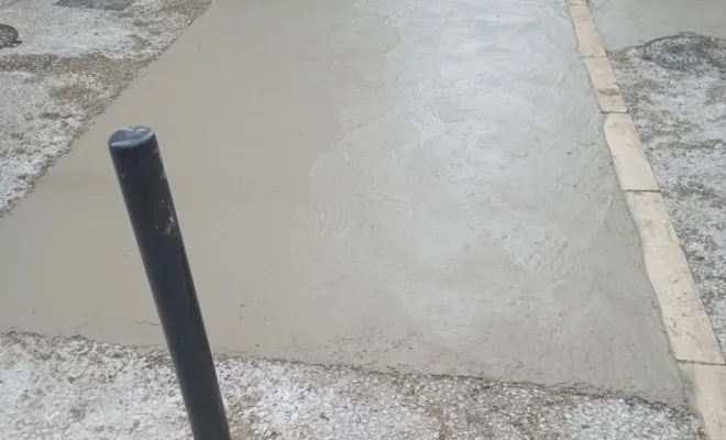 Coulage du béton frais et mise à niveau précise de la nouvelle plaque. Le traitement de surface (désactivation) va être appliqué pour révéler les granulats."