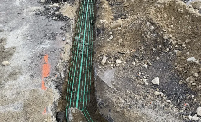 Tranchée ouverte sur route départementale avec pose de gaines de réseaux pour les partenaires télécoms.
