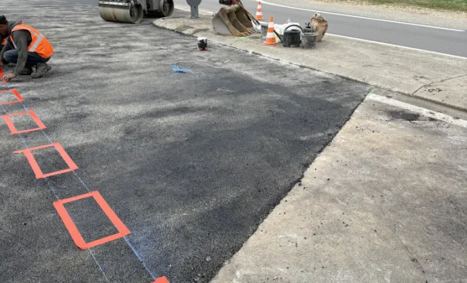 Marquage au sol réglementaire terminé sur une grande surface d'enrobé neuf sur la route départementale.