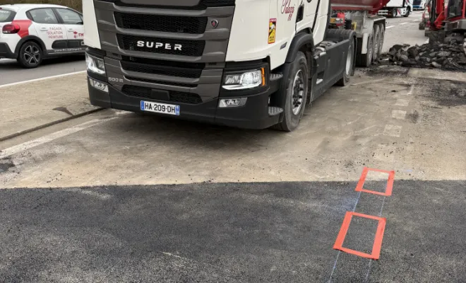 Camion benne de travaux publics stationné sur la zone de chantier sécurisée à Serpaize.