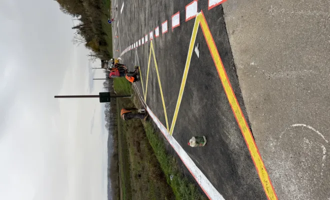 Vue d'ensemble de la chaussée départementale parfaitement réhabilitée avec ses zébras jaunes de signalisation.
