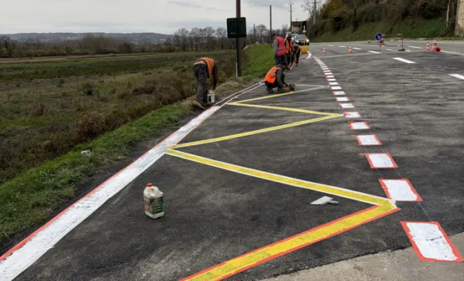 Résultat final des travaux publics avec une chaussée neuve, des marquages au sol propres et des bordures de trottoir terminées.