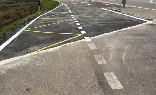 Résultat final des travaux publics avec une chaussée neuve, des marquages au sol propres et des bordures de trottoir terminées.