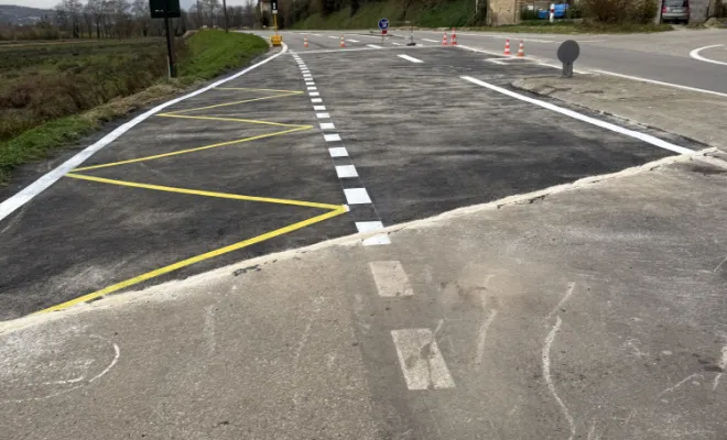 Marquage au sol réglementaire terminé sur une grande surface d'enrobé neuf sur la route départementale.