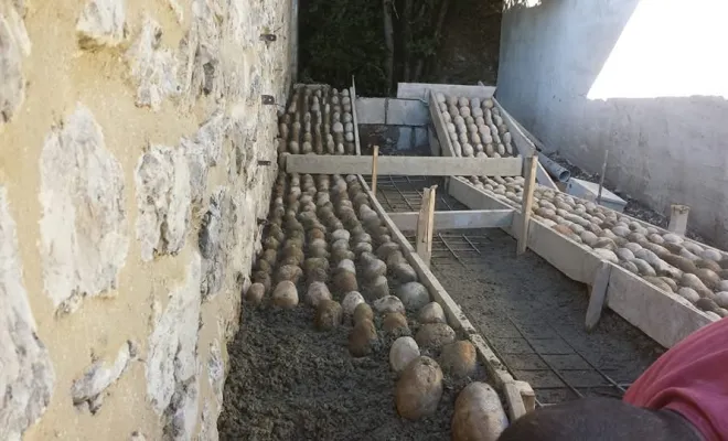 Vue d'ensemble du chantier de maçonnerie paysagère avant les finitions et le nettoyage des joints de galets.