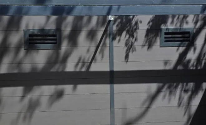 Détail des grilles de ventilation intégrées et du bardage composite gris anthracite posés par Electron TP