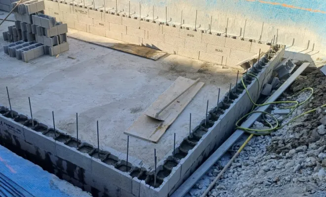 Dalle en béton coulée et élévation des blocs à bancher pour piscine