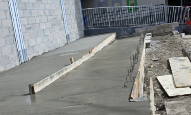 Coulage d'une rampe d'accès inclinée en béton avec paliers de repos intégrés